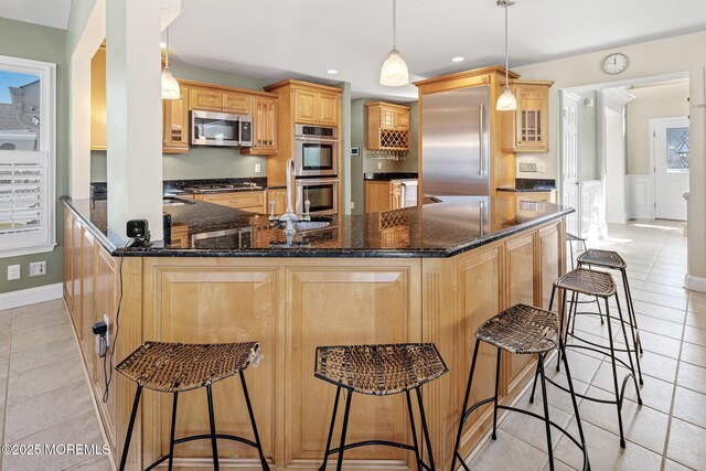 kitchen with appliances with stainless steel finishes, a peninsula, light tile patterned flooring, a kitchen bar, and recessed lighting