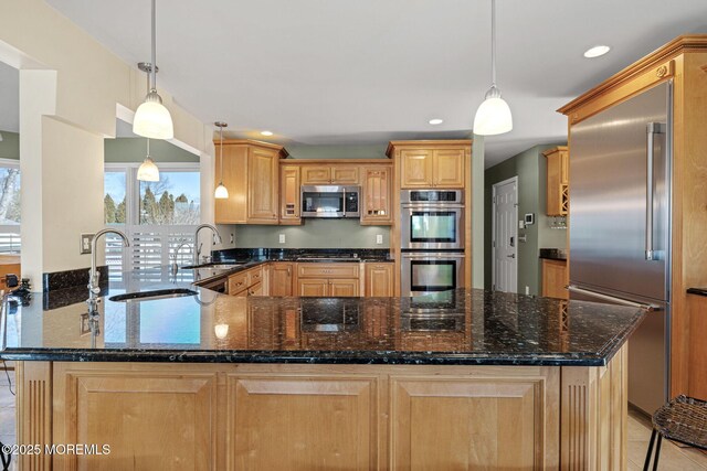 kitchen featuring stainless steel appliances, a peninsula, a sink, and a wealth of natural light