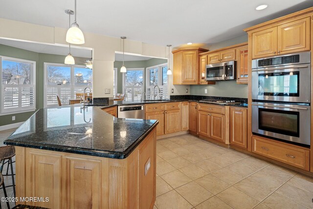 kitchen featuring stainless steel appliances, hanging light fixtures, a peninsula, and a sink