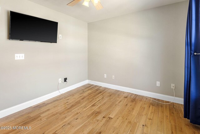 spare room featuring light wood-style floors and baseboards