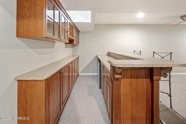 bar with baseboards, ceiling fan, and light colored carpet