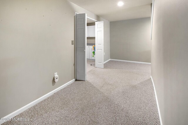 unfurnished room with light carpet and baseboards