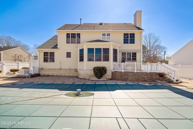 back of house with a fenced in pool, a patio, a chimney, fence, and a wooden deck