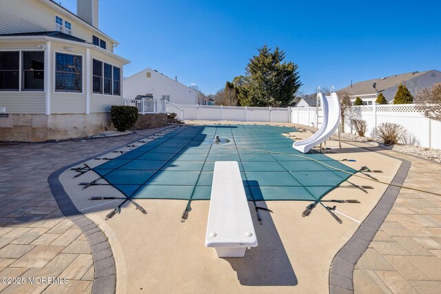 view of pool with a fenced in pool, a water slide, a fenced backyard, and a patio