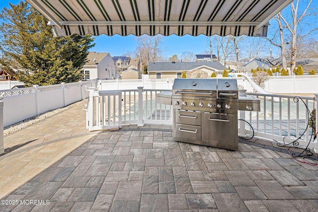 view of patio / terrace featuring a fenced backyard, a residential view, and a grill