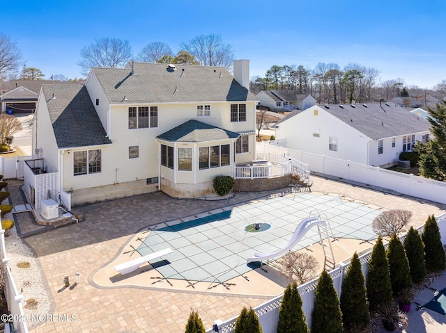 rear view of property with central AC, a patio area, and a fenced backyard