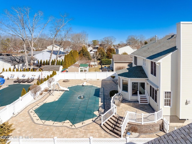 view of swimming pool with a patio area, a fenced backyard, a residential view, and a fenced in pool