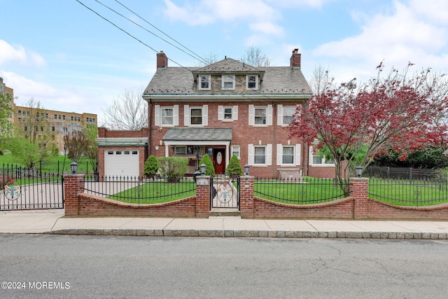 traditional style home with driveway, brick siding, a fenced front yard, and a front yard