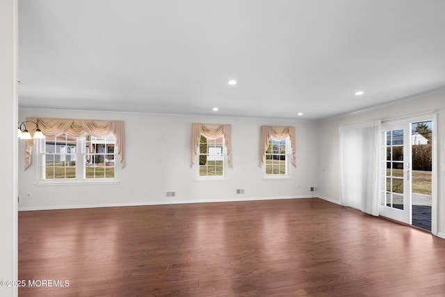 spare room with plenty of natural light and wood finished floors