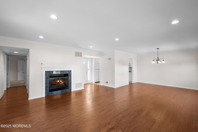 unfurnished living room featuring recessed lighting, wood finished floors, visible vents, and a high end fireplace