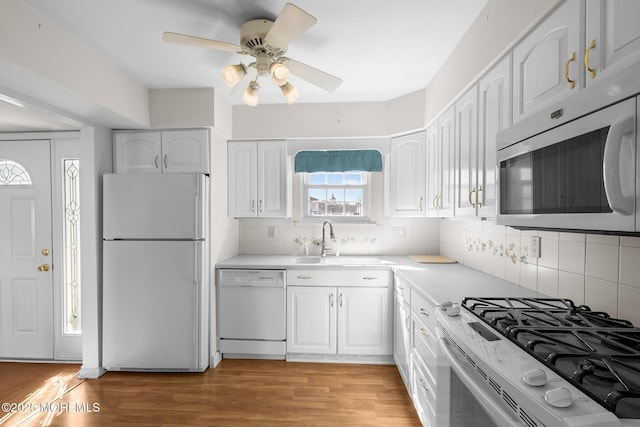 kitchen featuring white cabinets, white appliances, and light wood-type flooring