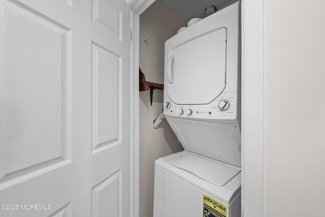 washroom featuring stacked washer and clothes dryer and laundry area