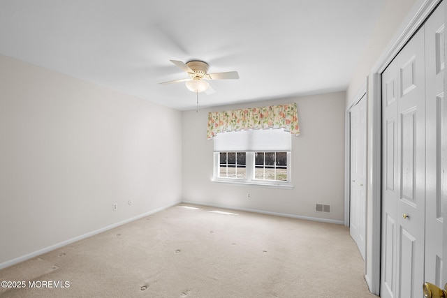 unfurnished bedroom featuring carpet flooring, baseboards, and visible vents