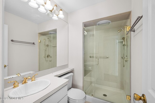 full bathroom with vanity, toilet, and a shower stall