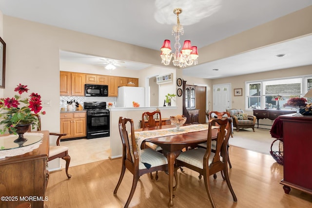 dining room featuring ceiling fan with notable chandelier and light wood-type flooring