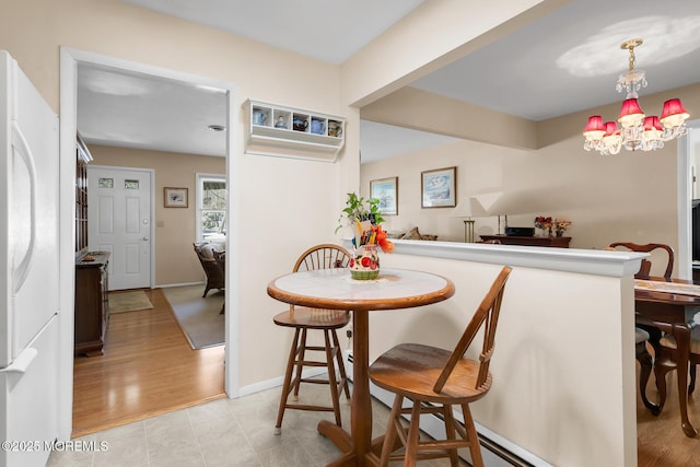 dining space featuring a notable chandelier, wood finished floors, and baseboards