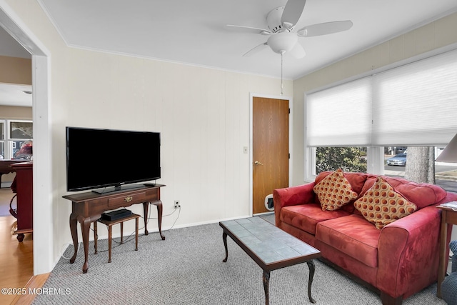 carpeted living room featuring ornamental molding, ceiling fan, and baseboards