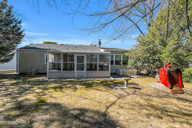 back of house with a sunroom and a yard