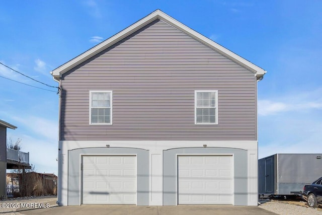 view of side of property featuring concrete driveway and an attached garage