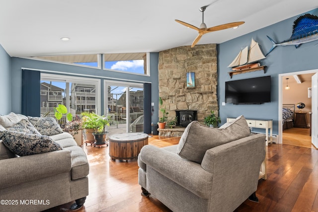 living area featuring vaulted ceiling, hardwood / wood-style flooring, and a ceiling fan