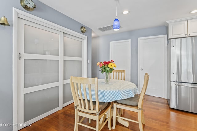 dining space with recessed lighting, visible vents, and wood finished floors