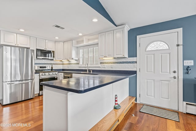 kitchen featuring stainless steel appliances, dark countertops, visible vents, and white cabinets