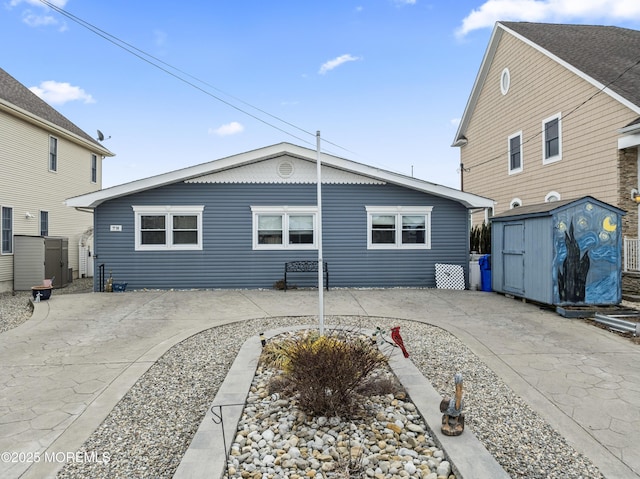 rear view of house with an outbuilding, a patio area, and a storage shed