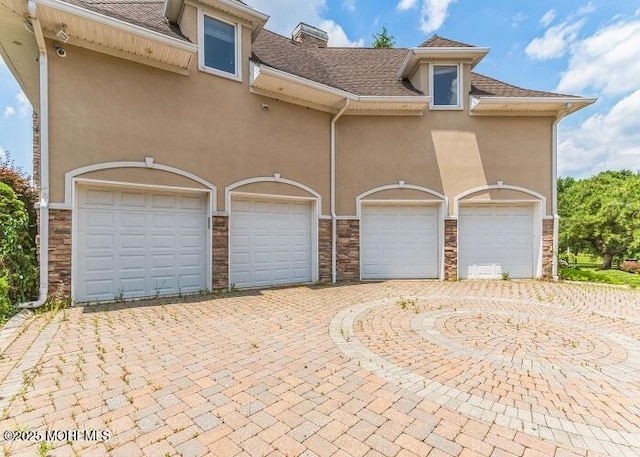 garage with decorative driveway