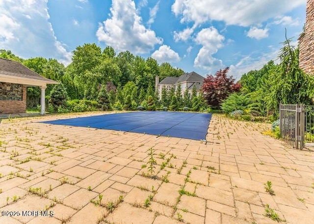 view of swimming pool featuring a covered pool and a patio