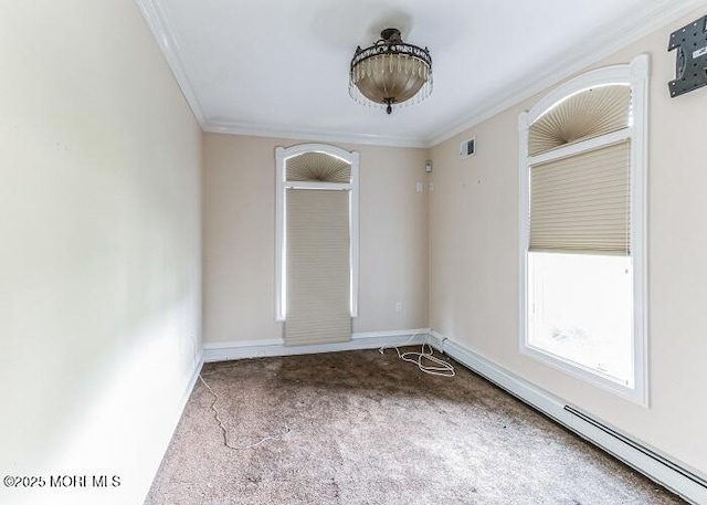 empty room with carpet flooring, baseboard heating, crown molding, and baseboards