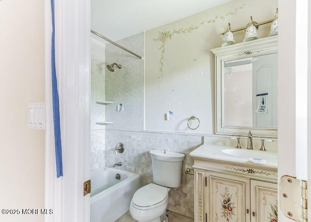 bathroom with vanity, shower / bathing tub combination, toilet, and tile walls