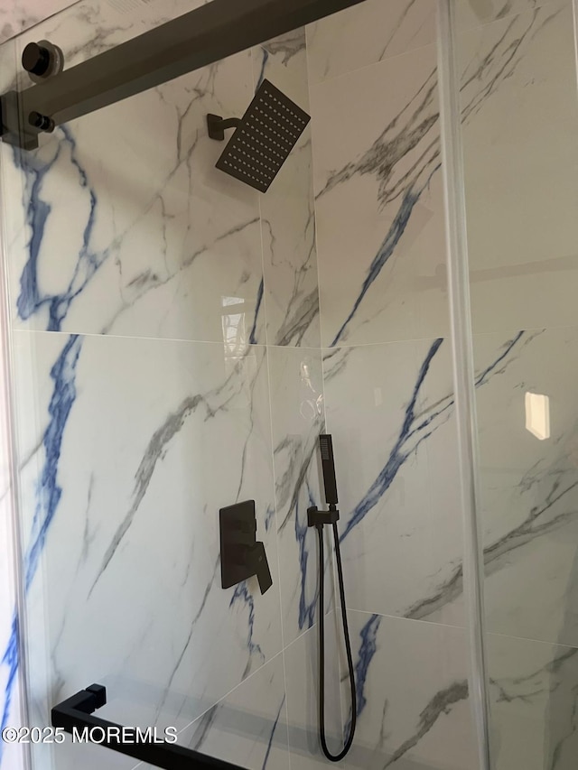 room details featuring a marble finish shower