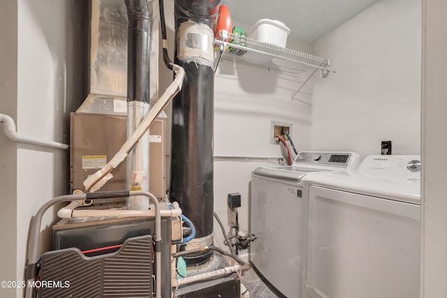 laundry area featuring heating unit, laundry area, and washer and clothes dryer