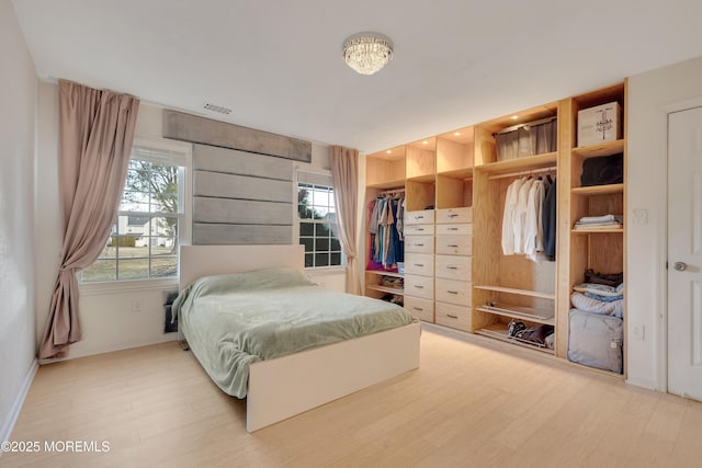 bedroom featuring baseboards, a closet, visible vents, and light wood-style floors