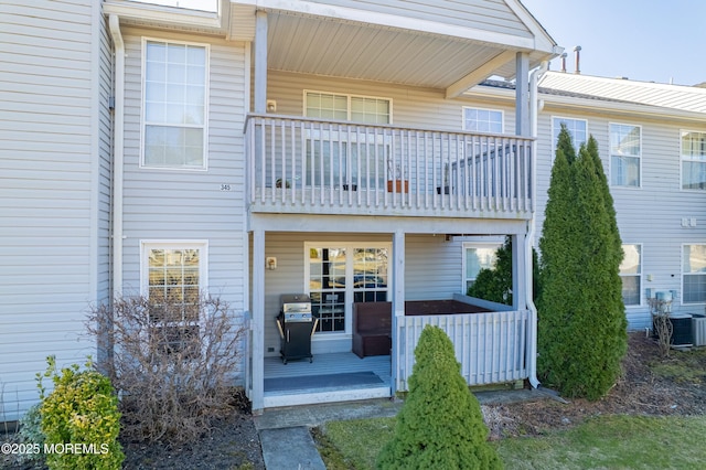 rear view of property featuring central AC unit and a balcony