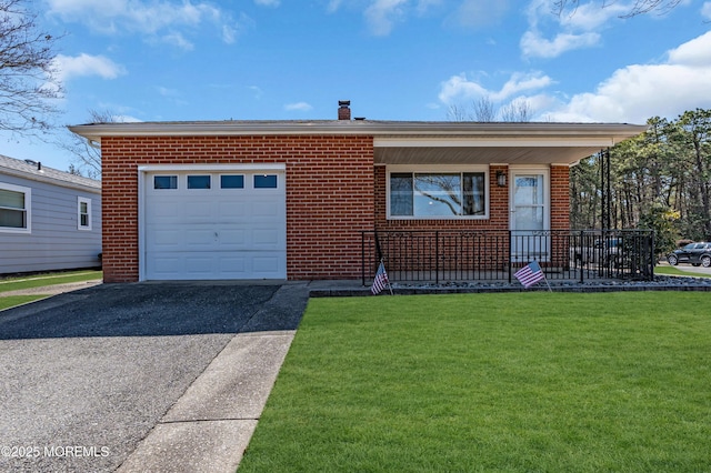 view of front facade with aphalt driveway, brick siding, a chimney, a garage, and a front lawn