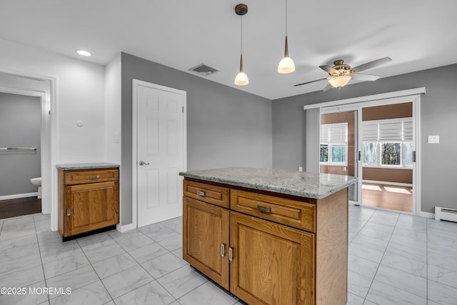 kitchen featuring a ceiling fan, visible vents, marble finish floor, brown cabinetry, and pendant lighting