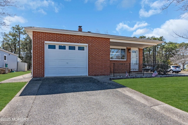 ranch-style house featuring brick siding, a chimney, a front yard, and aphalt driveway