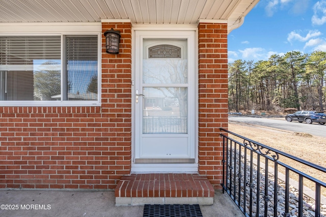 doorway to property with crawl space and brick siding