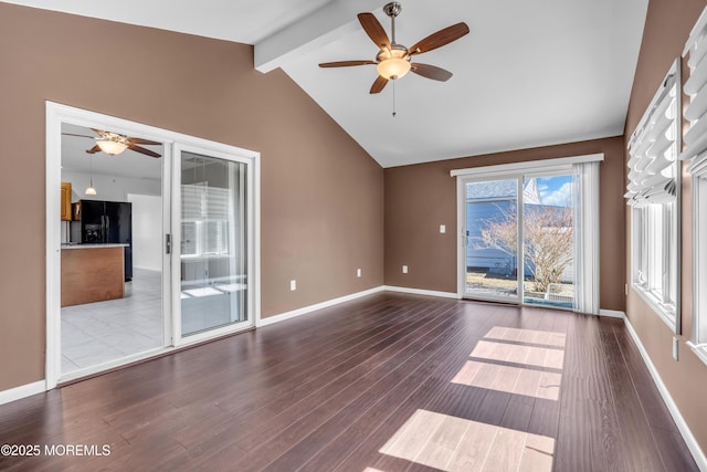 interior space featuring ceiling fan, lofted ceiling with beams, baseboards, and wood finished floors