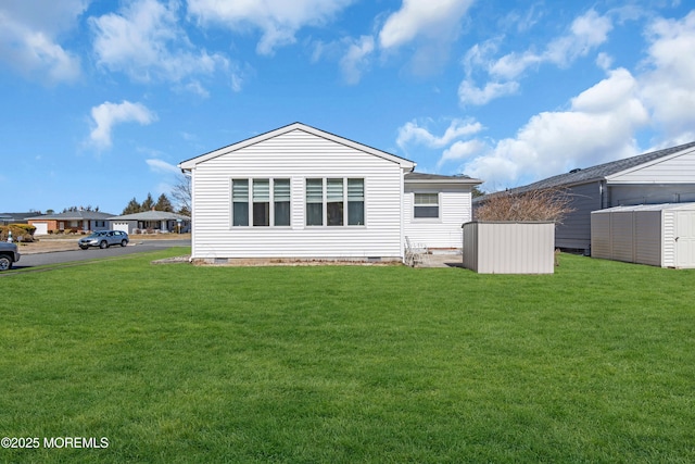 back of property featuring crawl space and a yard