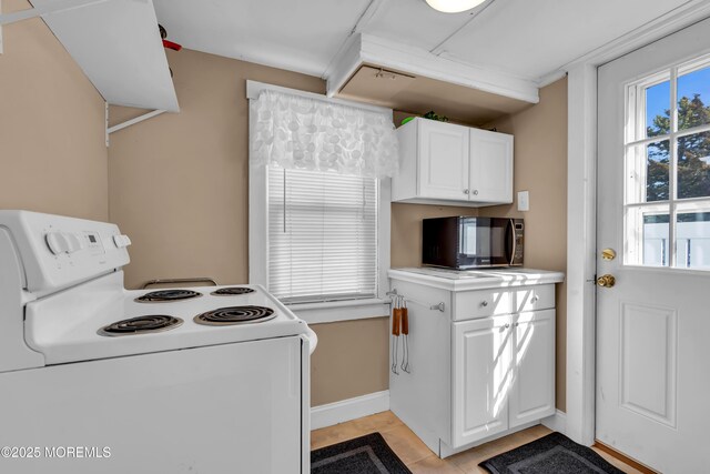 2-4 NE Central Ave, Seaside Park, NJ 08752 - kitchen with baseboards, black microwave, light tile patterned floors, white cabinets, and white electric stove