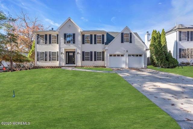 colonial-style house featuring a garage, driveway, and a front yard