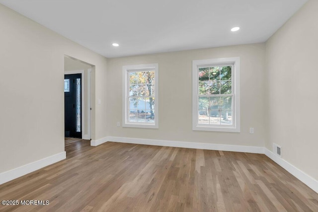 empty room featuring recessed lighting, wood finished floors, visible vents, and baseboards