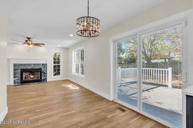 unfurnished living room with a fireplace, recessed lighting, visible vents, light wood-style flooring, and baseboards