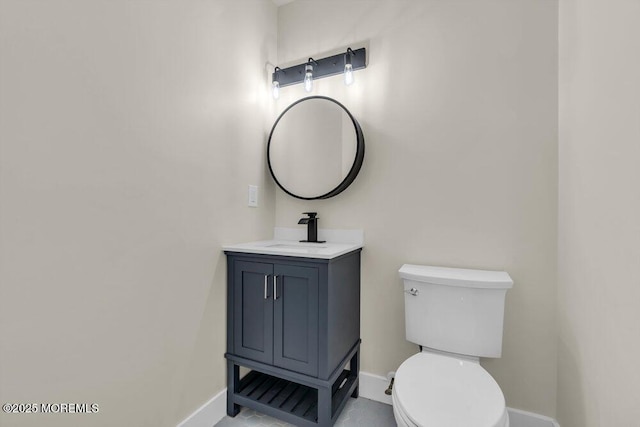 bathroom with vanity, toilet, and baseboards