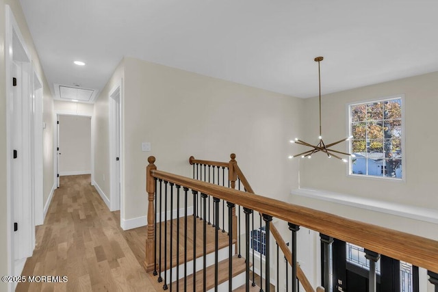 corridor with attic access, baseboards, an upstairs landing, light wood-style floors, and recessed lighting