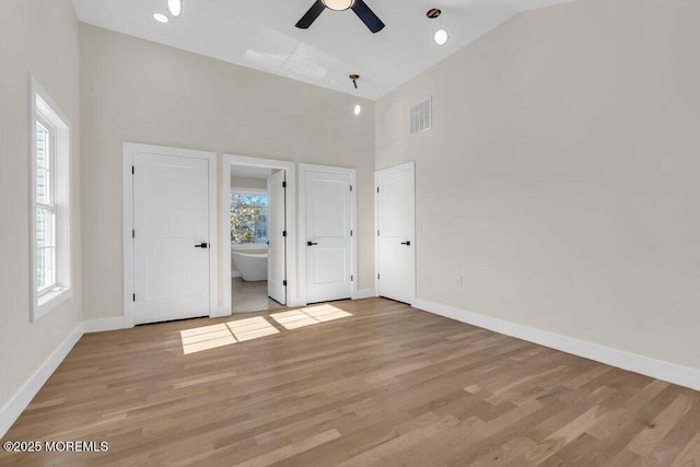 unfurnished bedroom with multiple windows, light wood-type flooring, visible vents, and baseboards