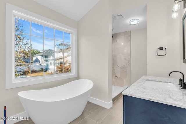 full bath featuring visible vents, baseboards, vanity, a freestanding tub, and a shower stall