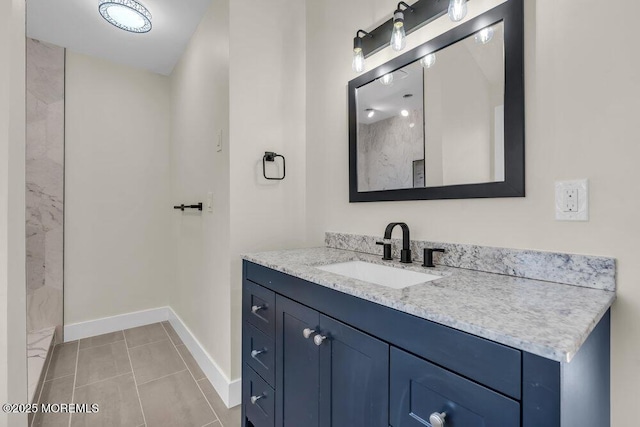 bathroom with a shower, tile patterned flooring, vanity, and baseboards